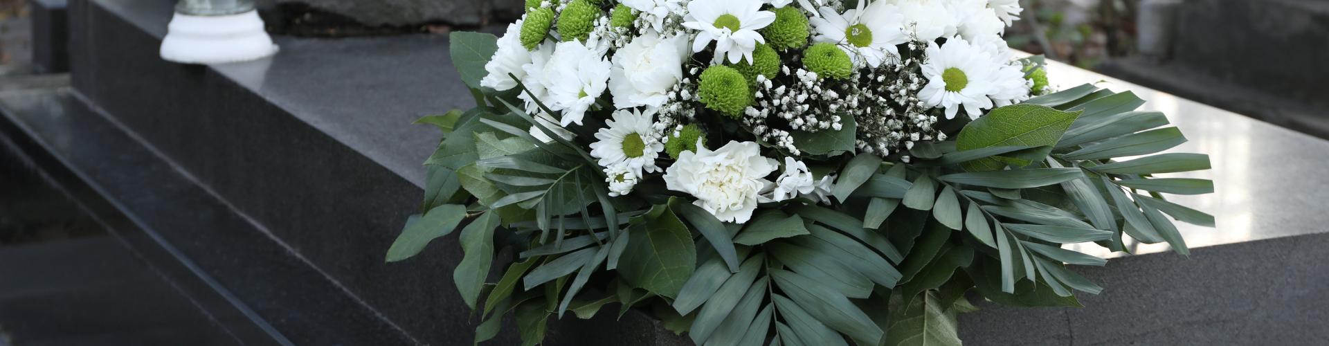 En bukett med vita blommor och gröna blad.